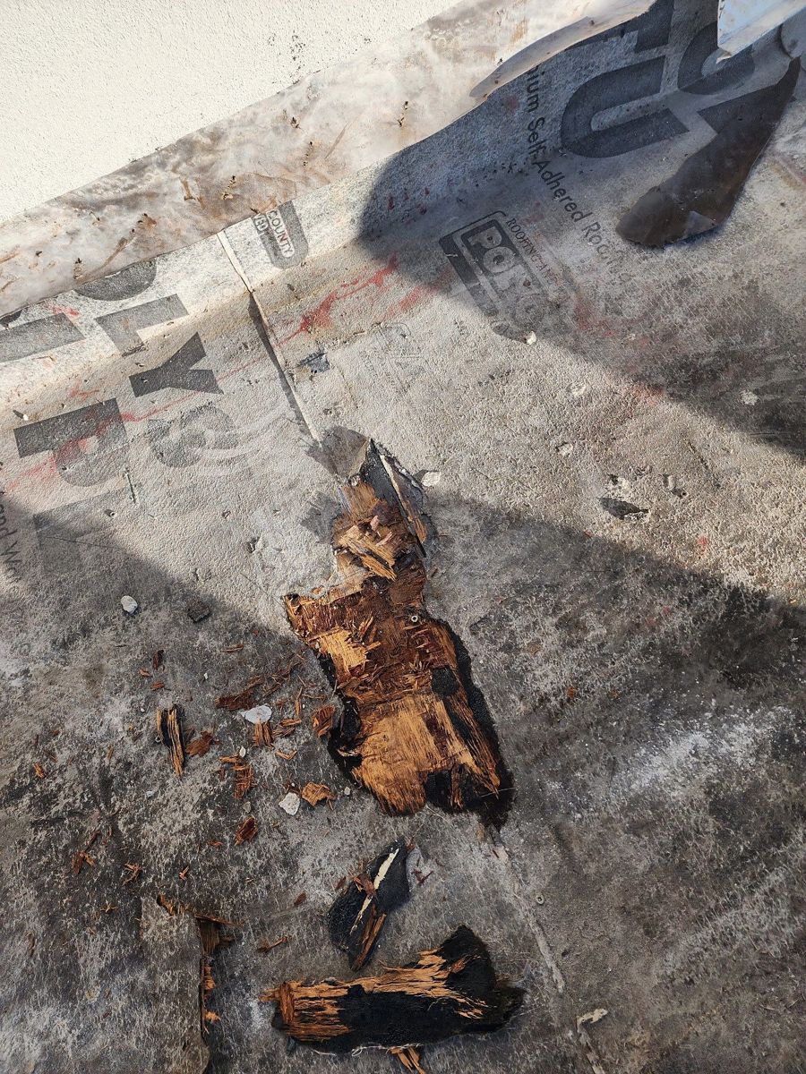 Close-up of deteriorated wood decking on a tile roof