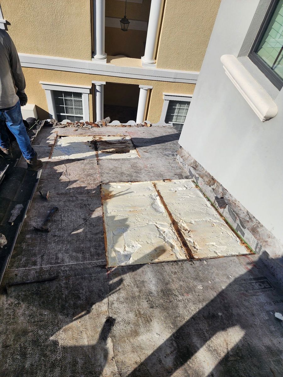 Two sections of roof deck cut out and filled with foam, beside a stucco wall